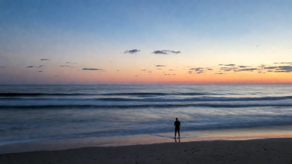 Person coping with PTSD triggers on a serene beach landscape for mental wellness.